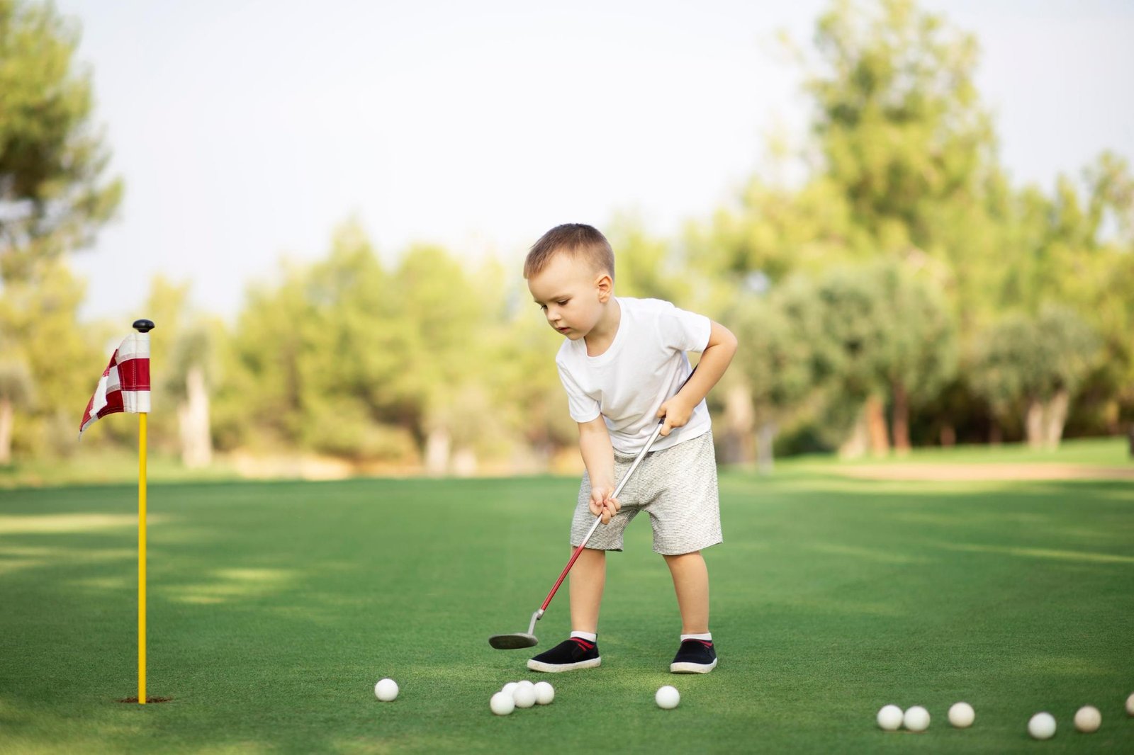 little-boy-playing-golf-with-golf-club-on-green-fi-2023-11-27-05-34-35-utc.jpg